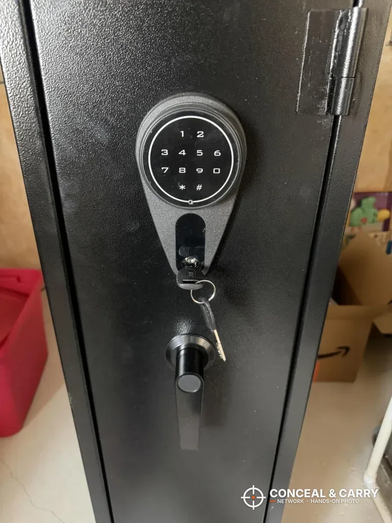 Close-up of the round KAER keypad with a key in the lock and the handle below