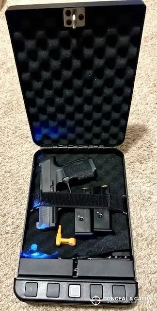 Langger lock box open with a compact pistol, magazines and blue light