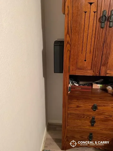 Langger slider safe mounted on a wall in a corner next to a wooden cabinet