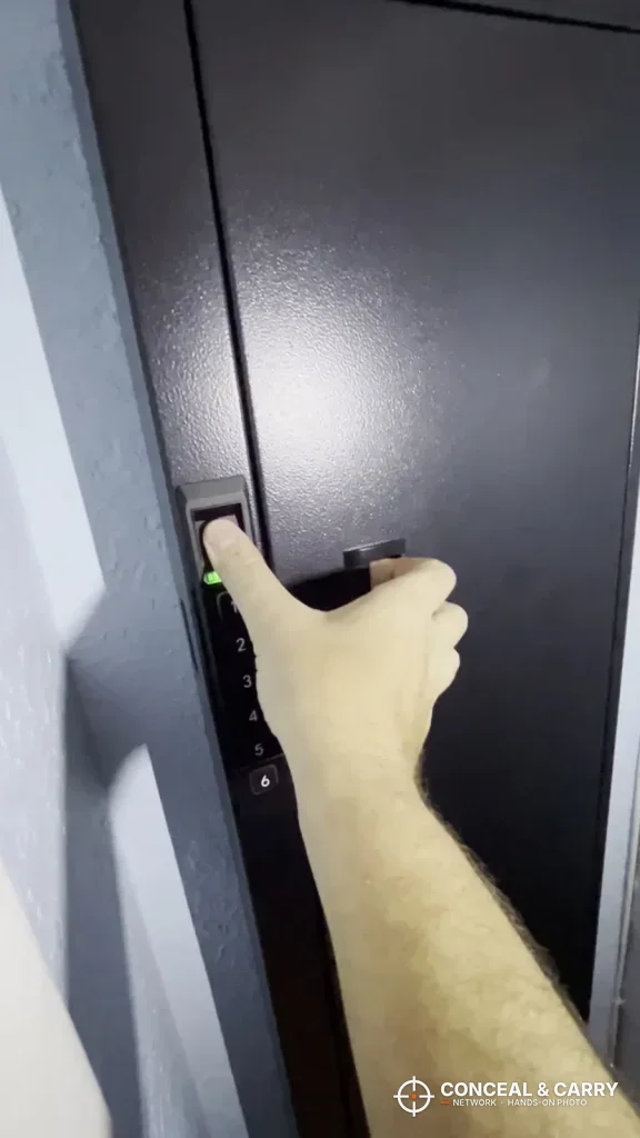 Finger on the Langger compact safe fingerprint reader beside the door handle