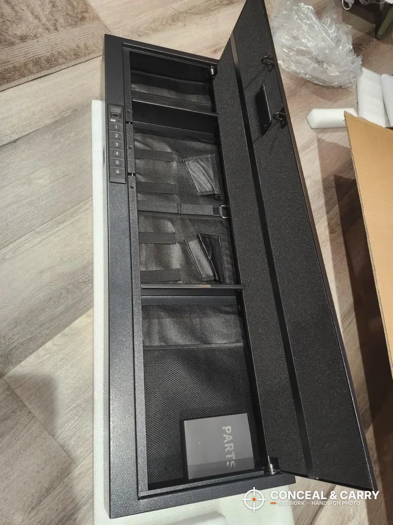 Langger compact long gun safe lying flat with the door open and fabric pockets inside