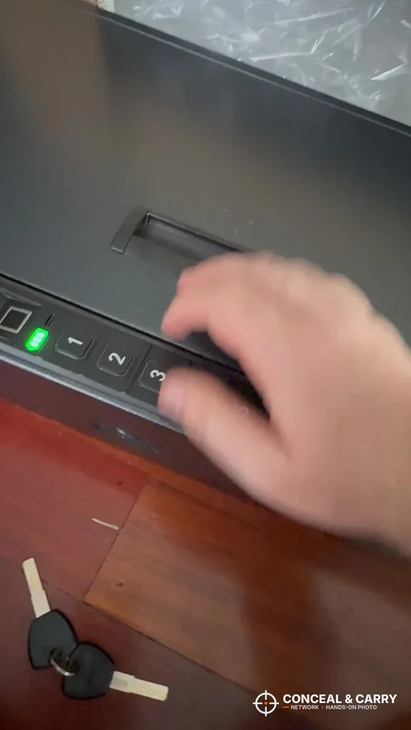 Langger compact safe keypad lit green with the backup keys lying beside it