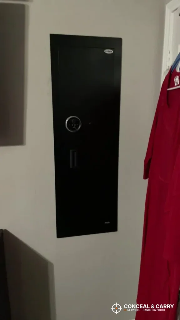 Black Langger in-wall long gun safe in a wall beside a red garment