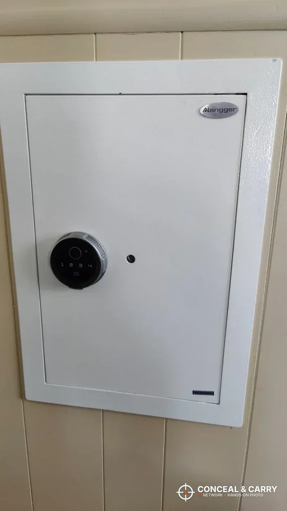 White Langger in-wall safe door set into a paneled wall