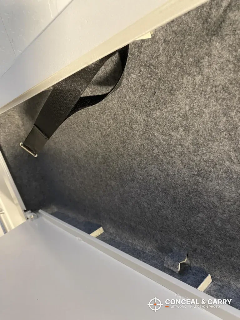 Gray lining and a black strap inside the Langger in-wall long gun safe