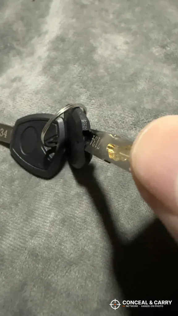 Hand holding the Langger under-bed safe emergency keys