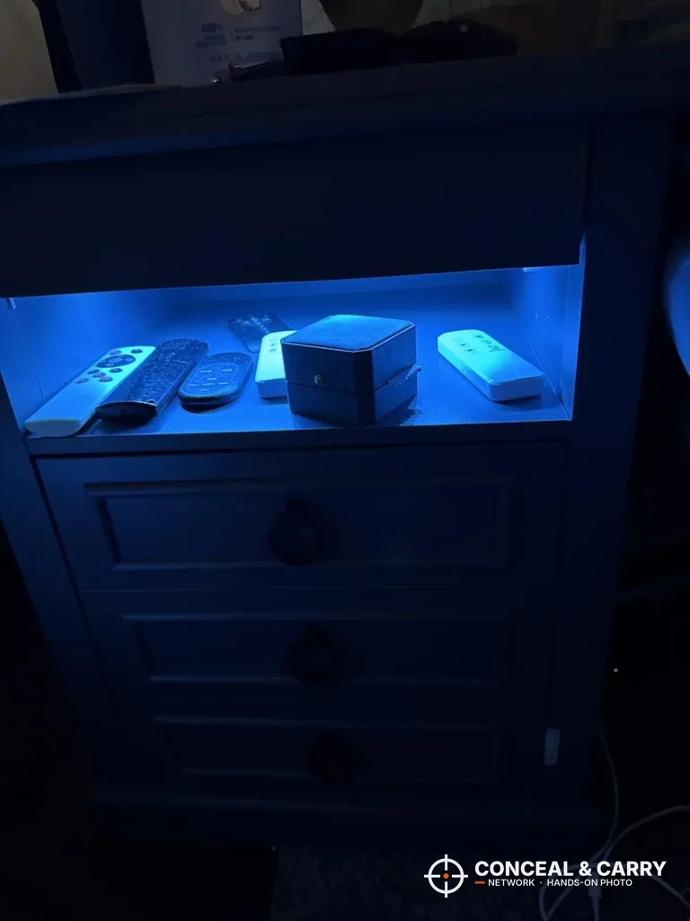 Lvifur open shelf glowing blue in a dark room with remotes on it