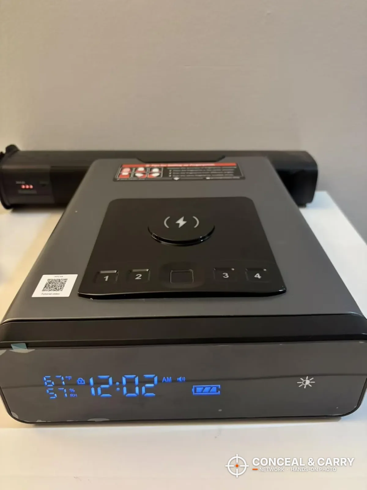 Mboko bedside biometric safe on a shelf with the clock display lit