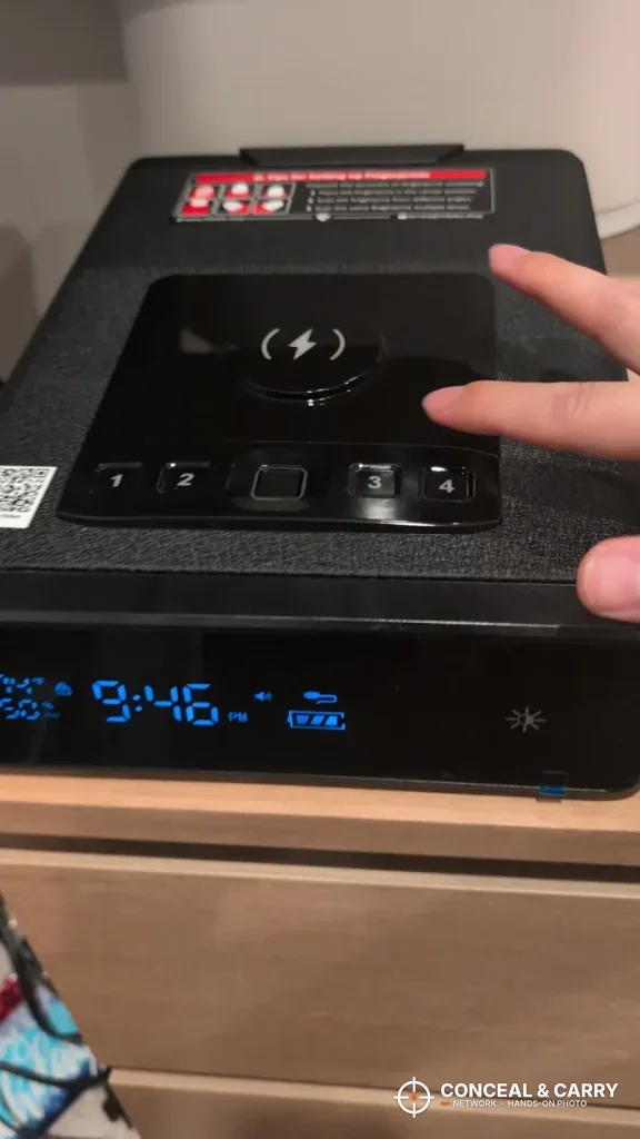 Finger reaching for the Mboko keypad on a nightstand