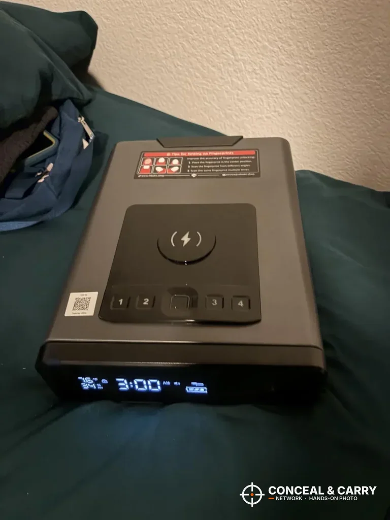 Mboko bedside safe on a bed, top view of the charging pad and keypad