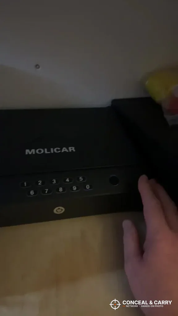 Hand beside the closed MOLICAR bedside safe on a shelf