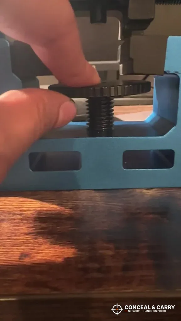 Hand turning the adjustment knob under a slide in the NcSTAR VISM sight tool