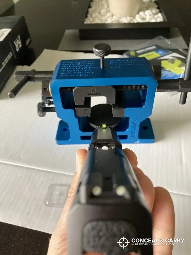 Pistol sights lined up in front of the NcSTAR VISM sight tool