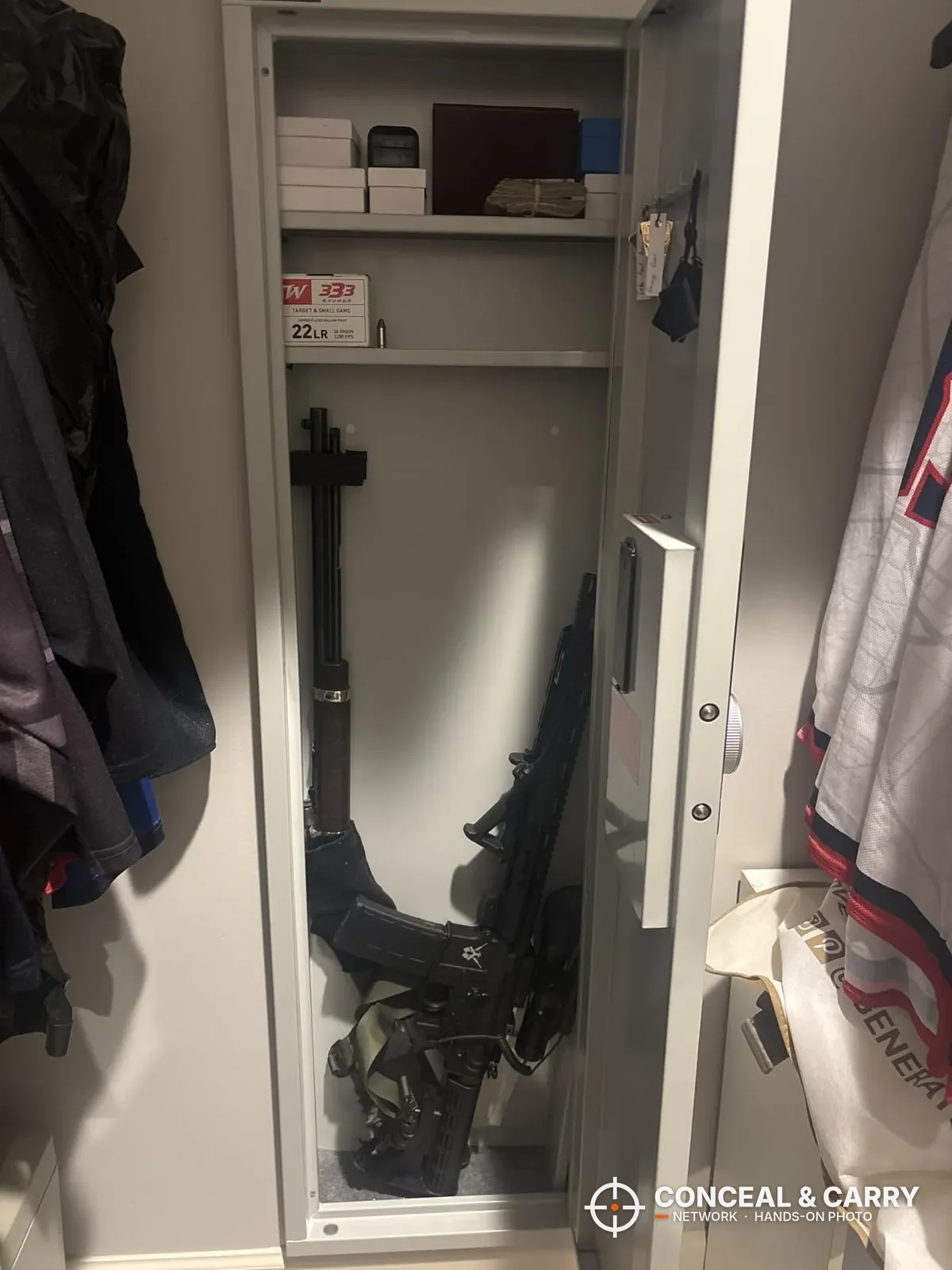 Omethey in-wall safe open in a closet with long guns below and shelves above