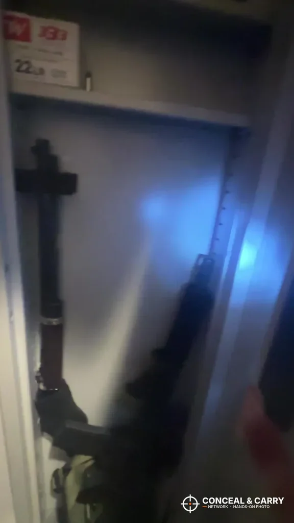 Darker view inside the Omethey in-wall safe with long guns standing upright