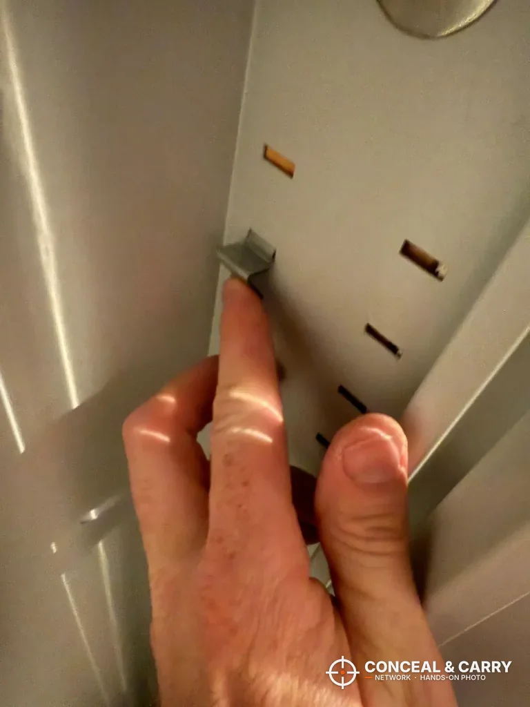 Hand setting a shelf clip into the side slots of the Omethey in-wall safe