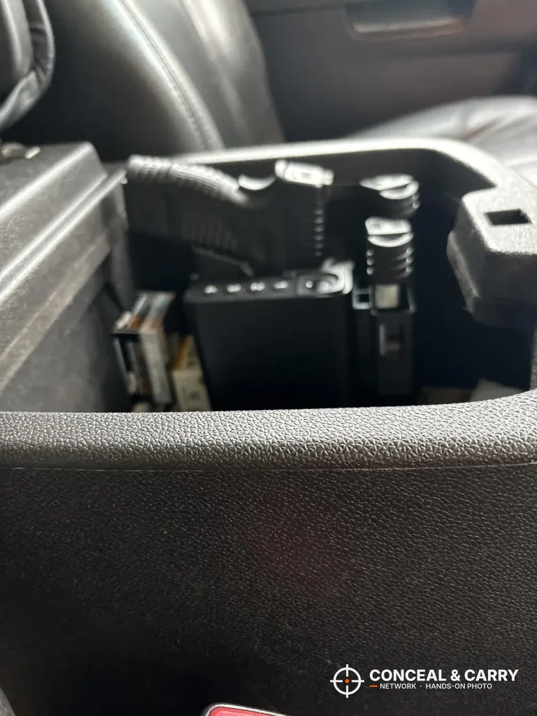 ONNAIS open-design safe mounted in a vehicle center console with a pistol
