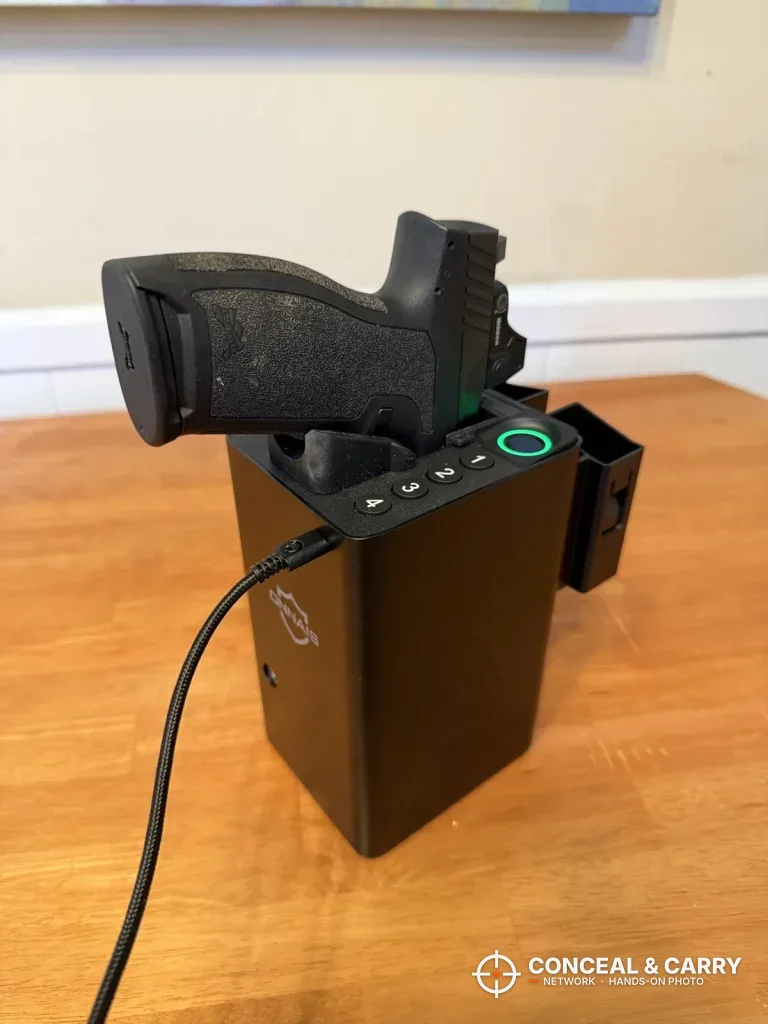 Pistol seated grip-up in the ONNAIS open-design biometric pistol safe on a table