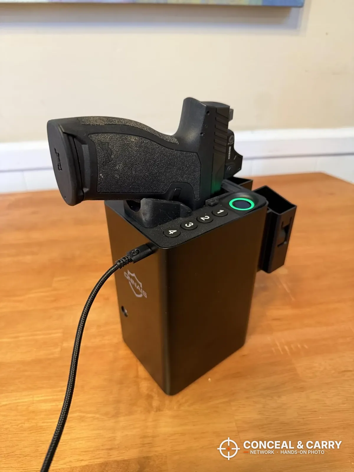Pistol seated grip-up in the ONNAIS open-design biometric pistol safe on a table