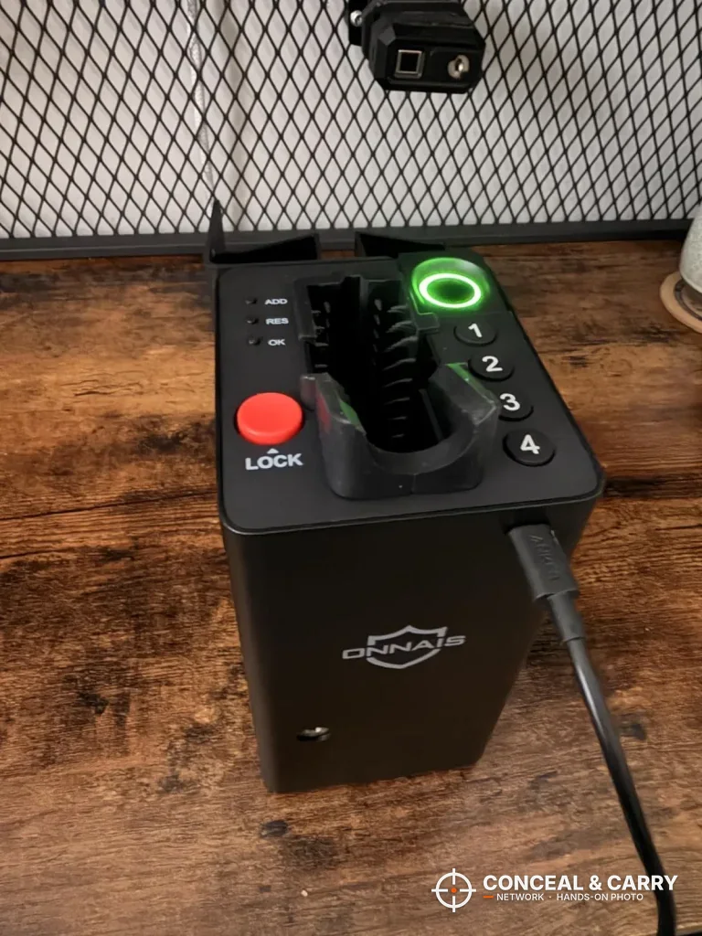 ONNAIS open-design safe on a desk with the charging cable plugged in