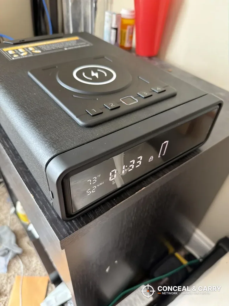 ORARAER smart charging safe on a dark stand, angled to show the clock