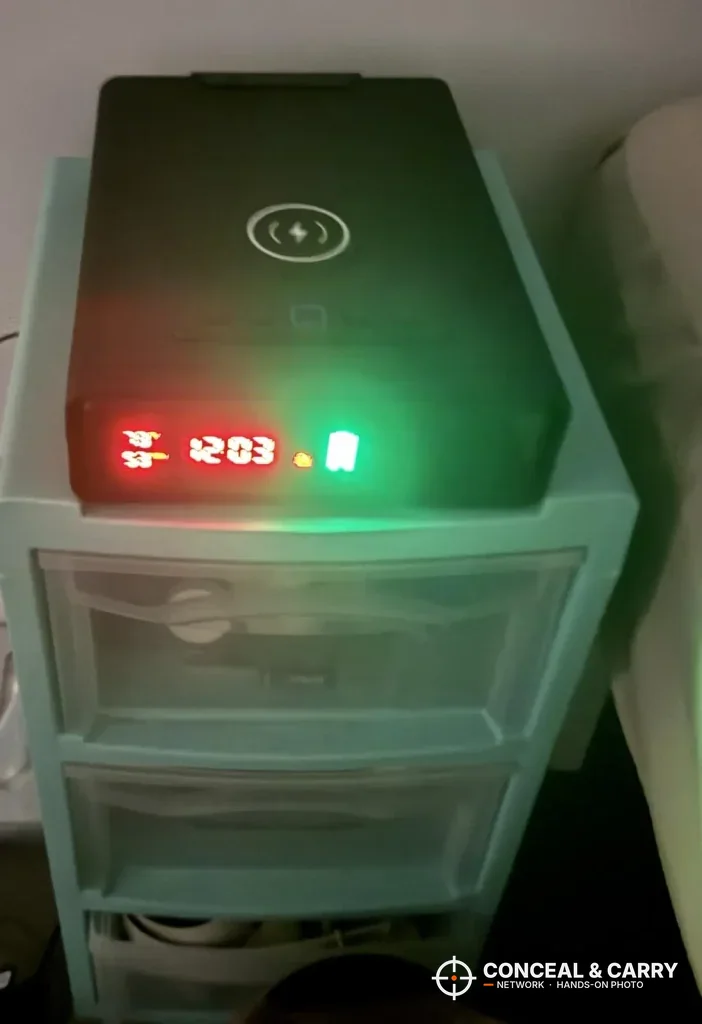 ORARAER safe glowing red and green on a bedside stand in a dark room