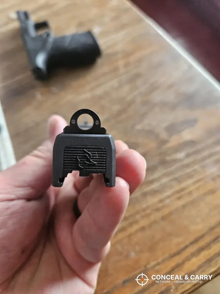 Rear of a Glock slide with its rear sight, the part that goes into the Pridefend sight pusher