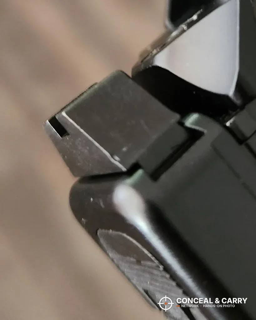 Close-up of an angled Glock rear sight in the slide dovetail, the job the Pridefend tool is built for