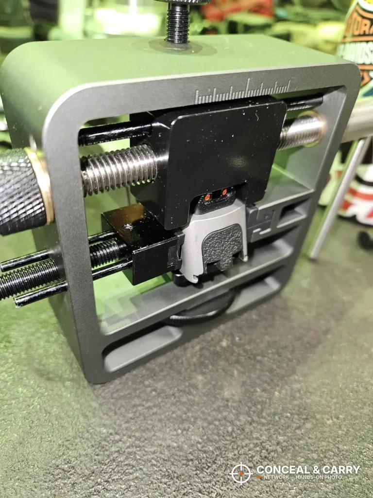 Pridefend Glock sight pusher on a workbench with a slide clamped in place