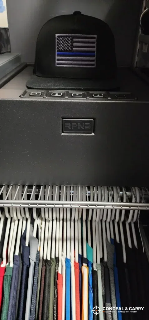 RPNB 4-pistol safe on a closet shelf above hanging clothes