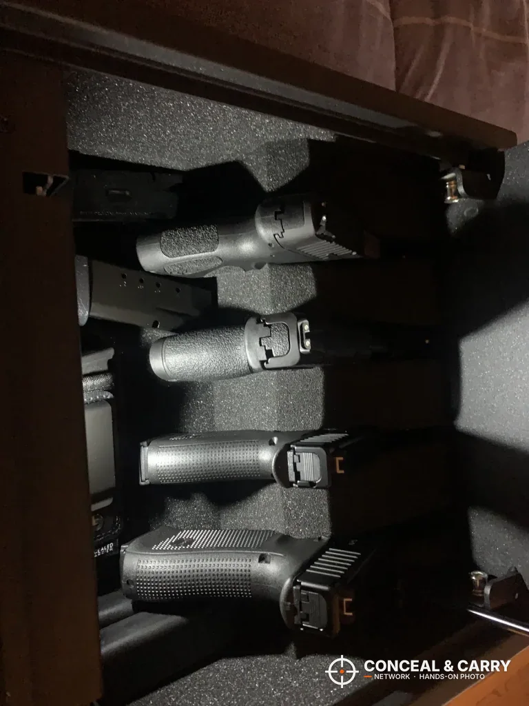 Four pistols racked in the RPNB 4-pistol safe inside a wooden cabinet