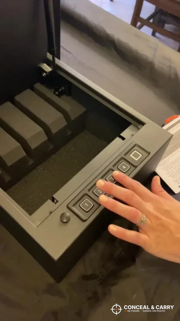 Hand on the RPNB 4-pistol safe keypad with the lid open