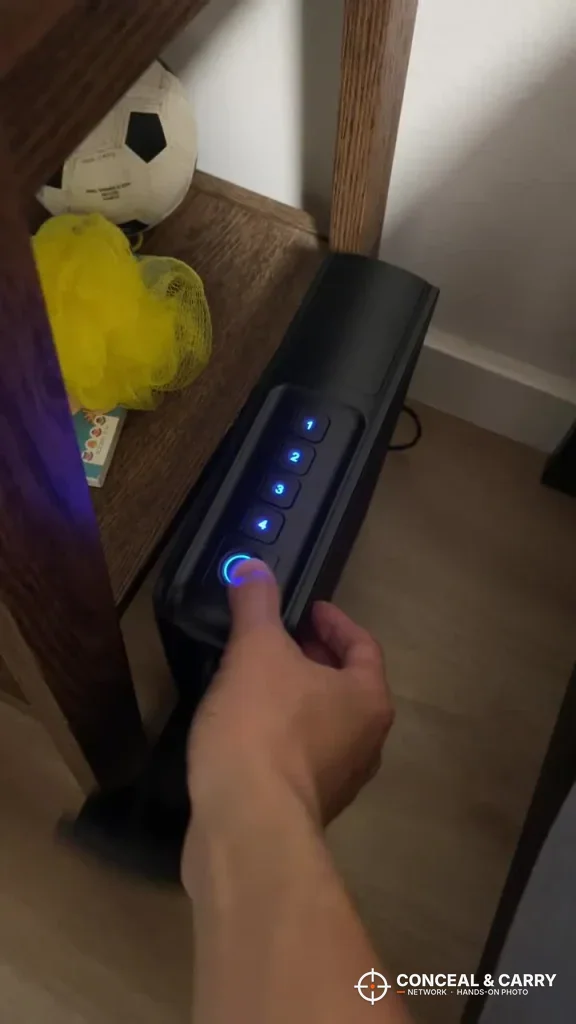 Finger on the RPNB bedside safe fingerprint reader with the keypad lit blue