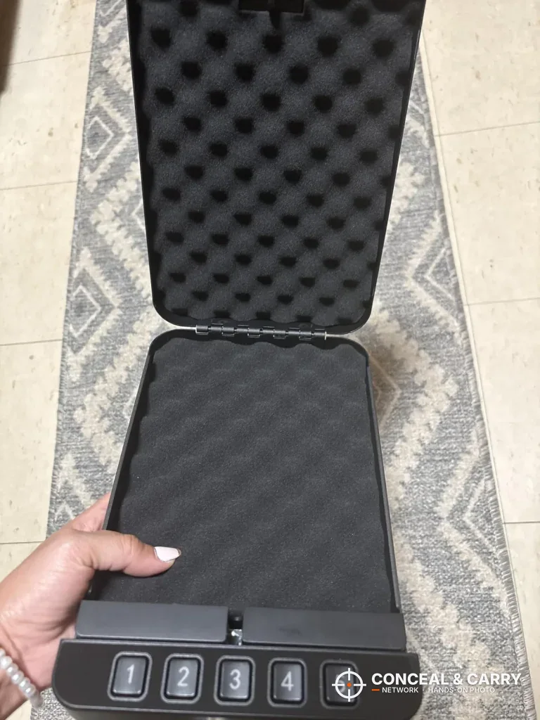 Hand holding the RPNB car gun safe open to show the foam lining