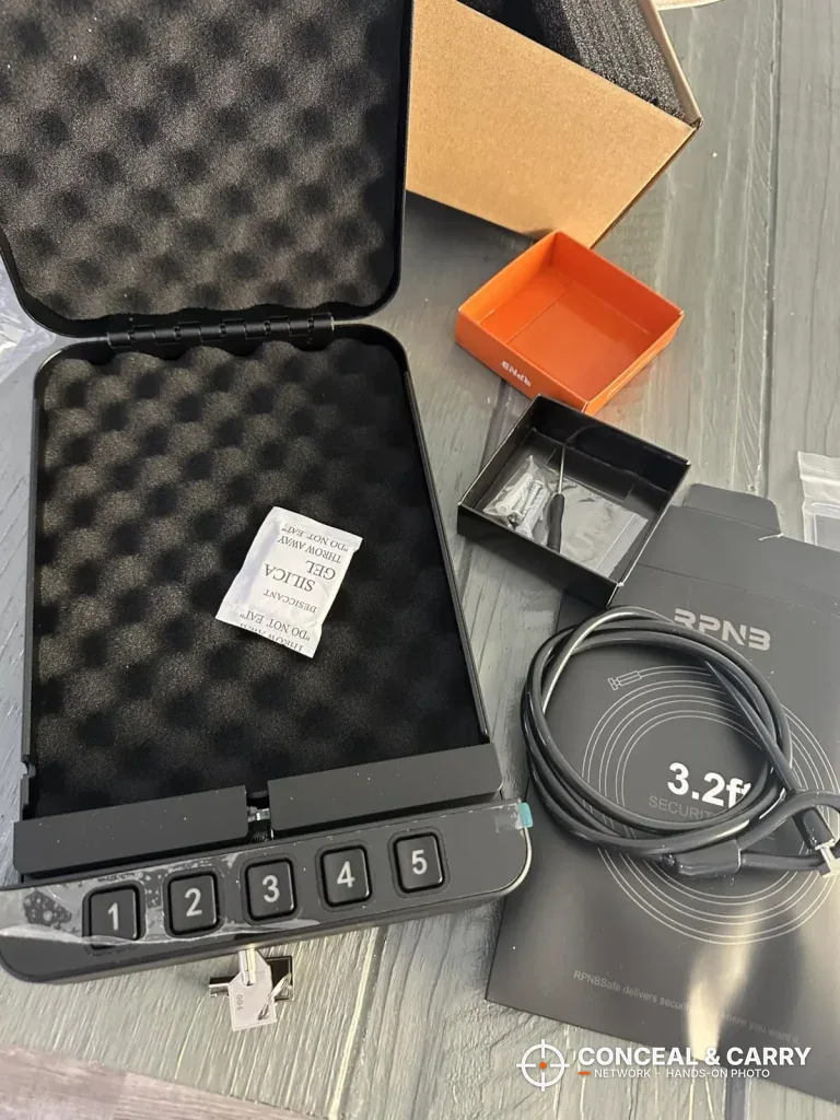 RPNB car gun safe open with keys and a coiled cable laid beside it