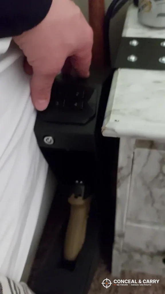 Hand on top of the RPNB RP311F mounted beside a bed with the drawer open