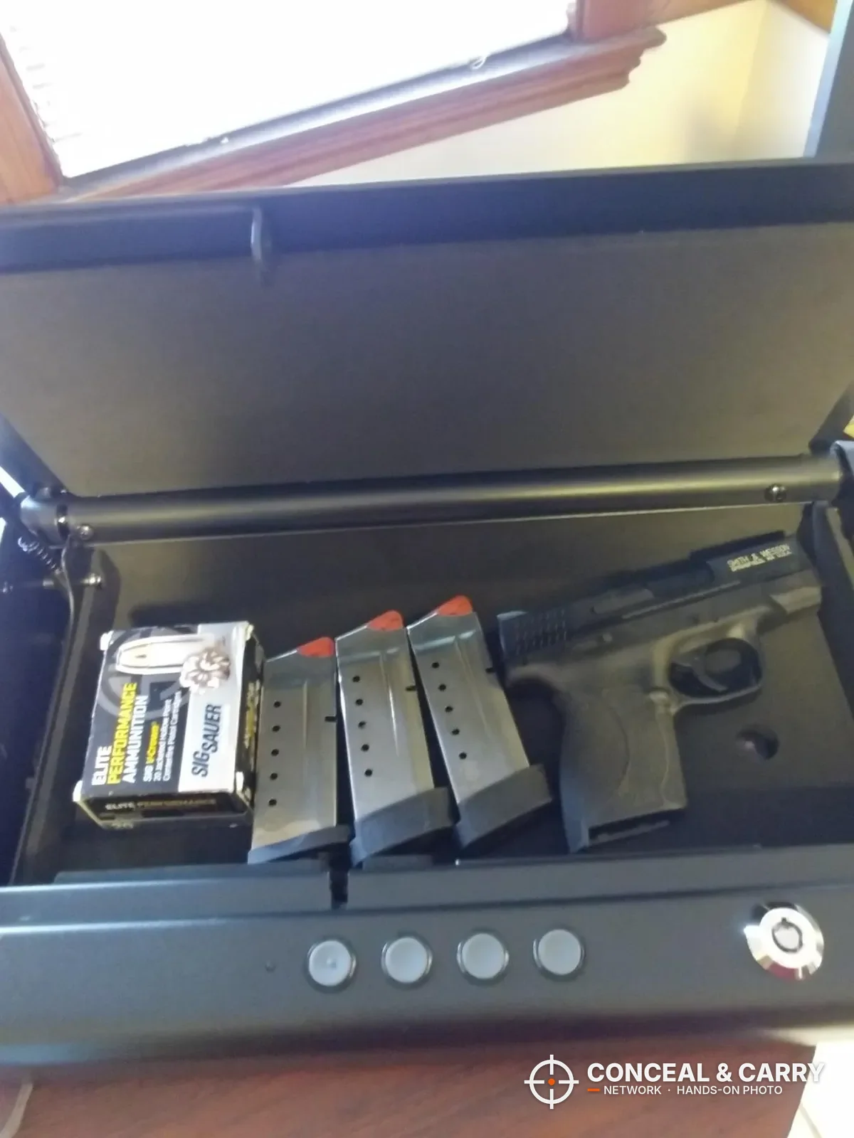 SentrySafe QAP2E open with a compact pistol, three magazines and a box of ammo inside