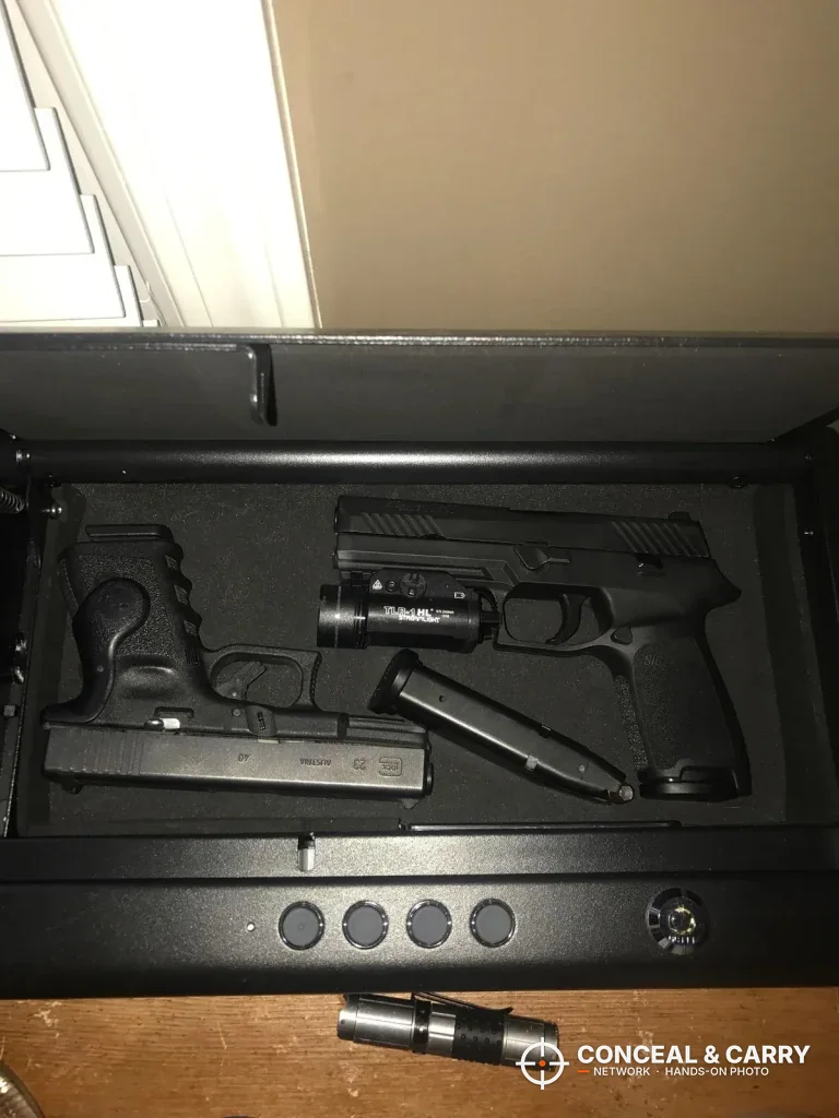 SentrySafe QAP2E holding two pistols, one with a weapon light