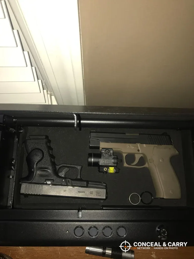 Pistol with a weapon light beside a tan-framed pistol in the SentrySafe QAP2E