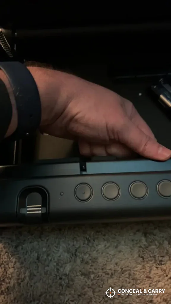 Hand reaching into the SentrySafe QAP2BLX as the lid lifts, fingerprint reader below
