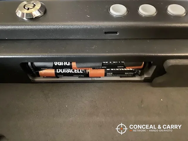 Four AA batteries in the compartment inside the SentrySafe QAP2BLX front panel