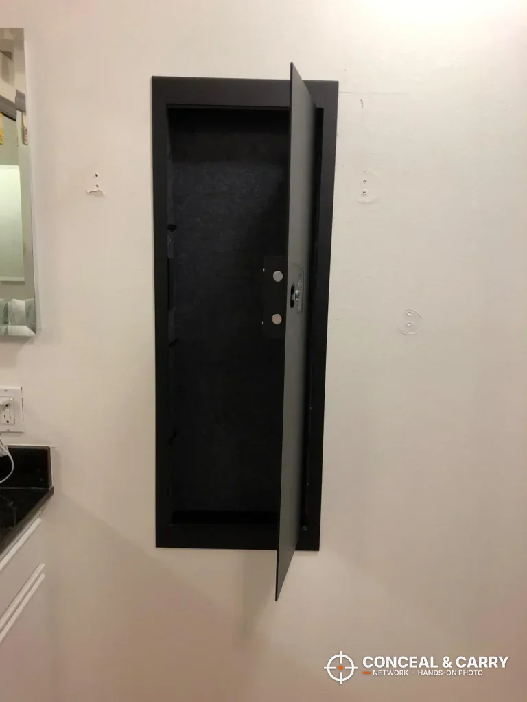 SnapSafe in-wall long gun safe open and empty, showing the long, carpeted interior
