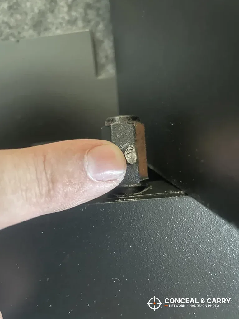 Close-up of a small metal bracket on the SnapSafe in-wall long gun safe