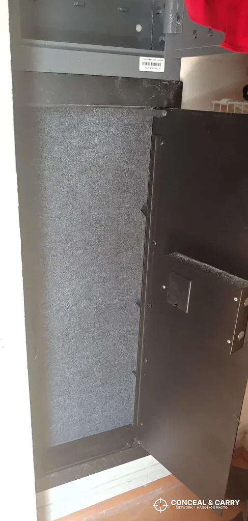 SnapSafe in-wall safe door open, showing the lock housing on the inside of the door