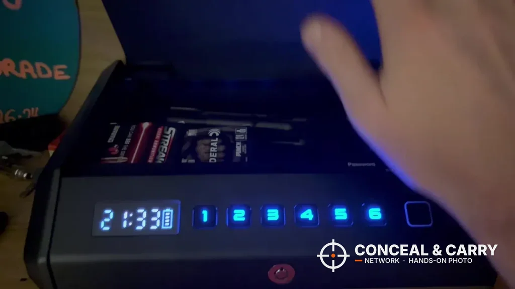 Hand lifting the TOPMEDA safe lid with the display and keypad lit