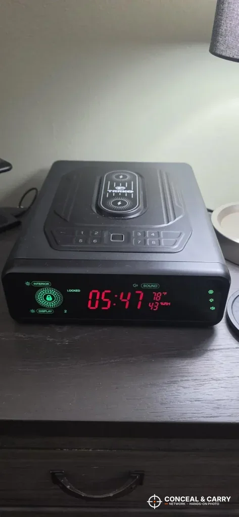 TRRKO charging safe on a nightstand with its front display lit