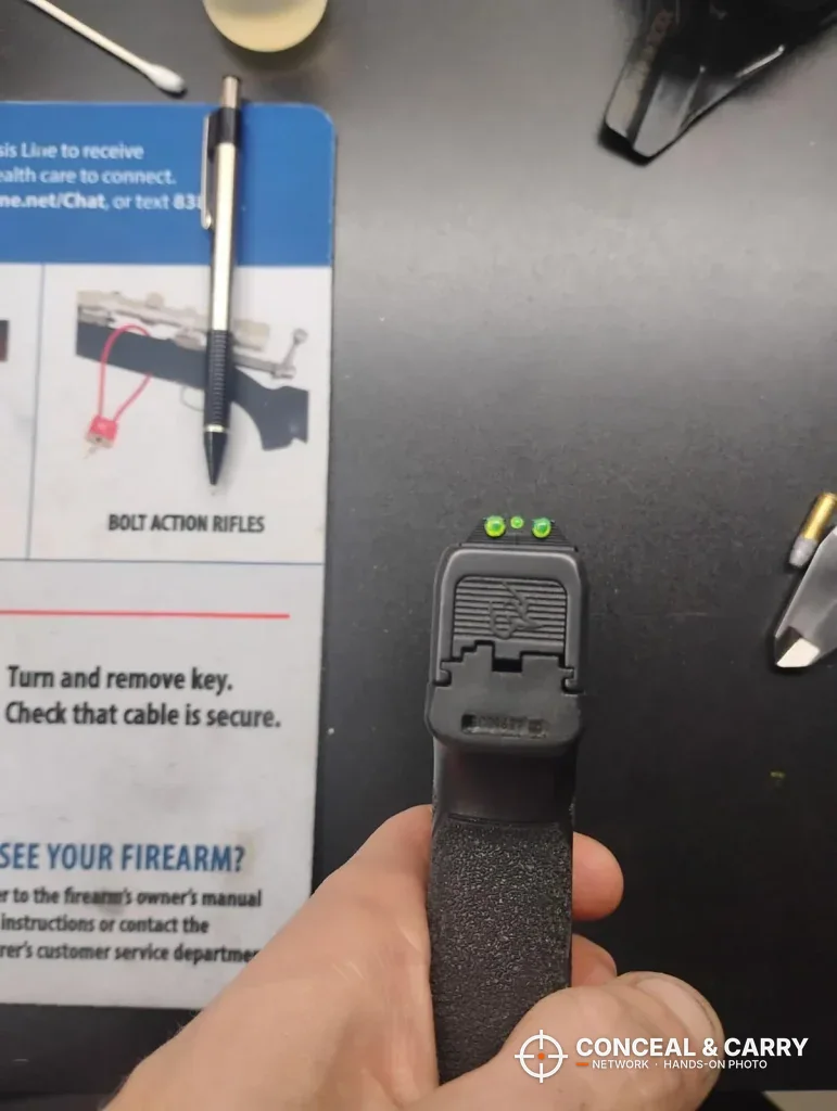 Pistol rear sight seen from behind, the face a TRUGLO sight tool shoe pushes on