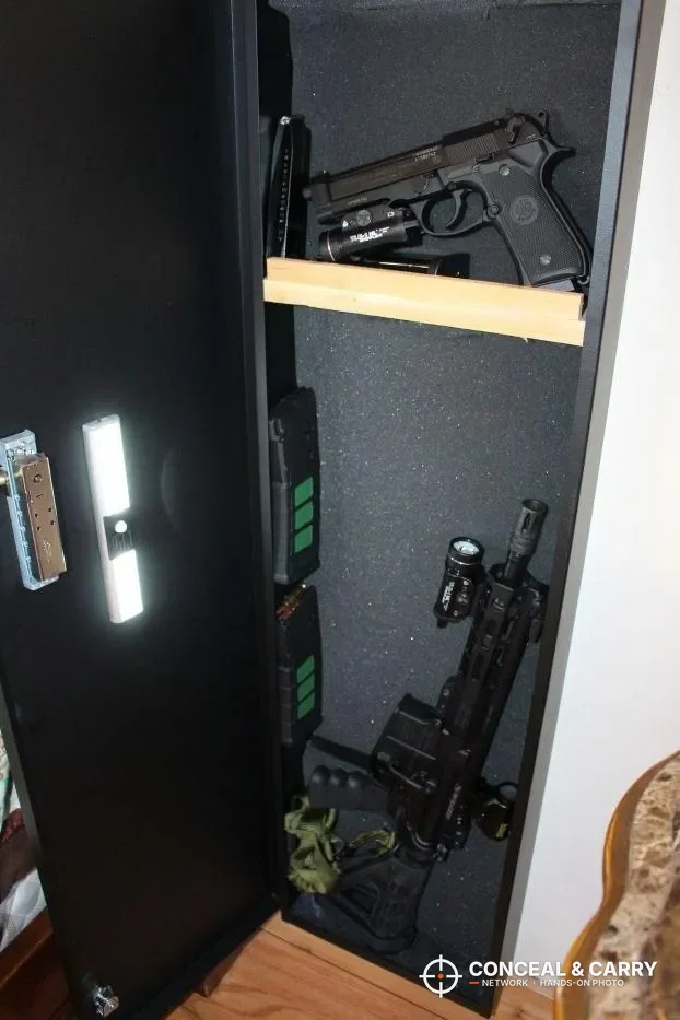 Upright V-Line long gun safe with a wooden shelf holding a handgun above a rifle