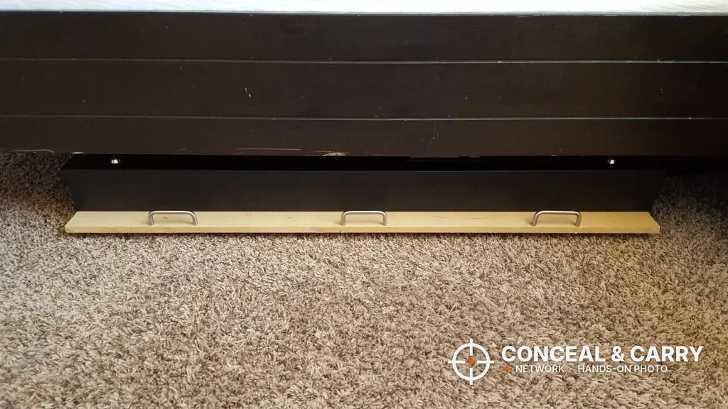 V-Line long gun safe slid flat under a bed on a wooden board