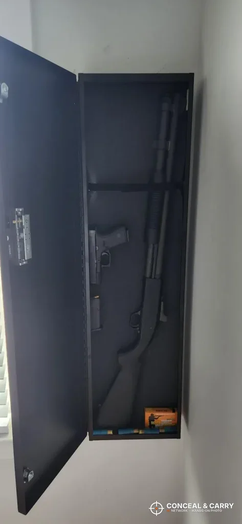 V-Line long gun safe mounted upright on a wall with the door open and a long gun inside